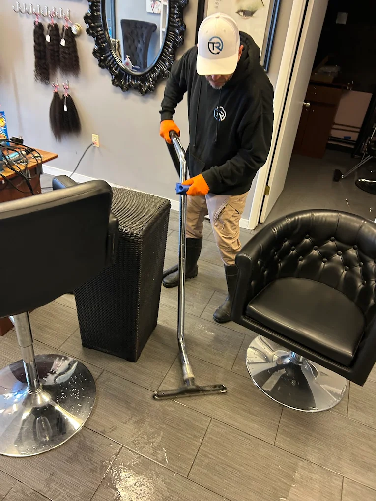 Crew member extracting water from a flooded salon floor