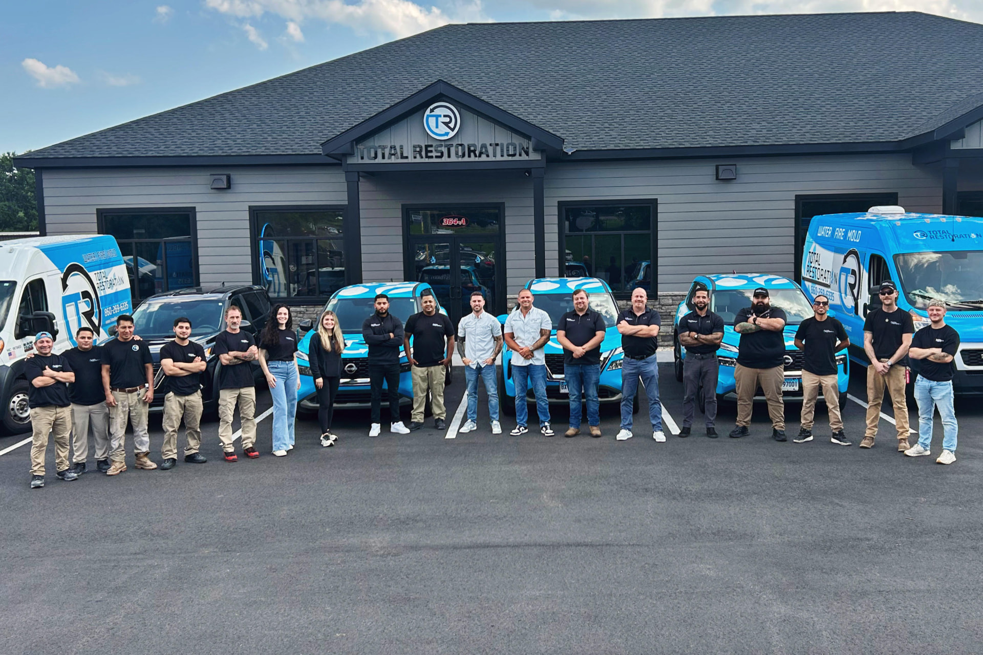 The Total Restoration team in front of their Berlin, CT headquarters and service vehicles